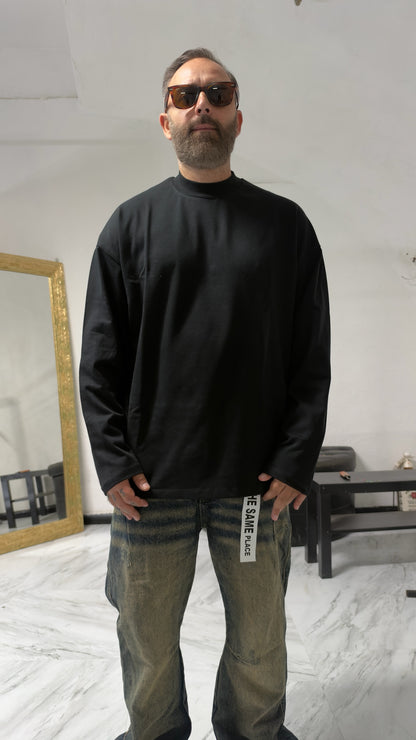 Uomo con occhiali da sole indossa una maglia a maniche lunghe MOMAREVENGE nera a collo alto dal taglio oversize